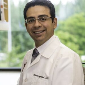 Dr. Meisam Nejad smiling in lab coat.