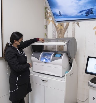 Cutting-edge technology at Dr. Asha Madhavan's dental office - CEREC same day crown machine in action
