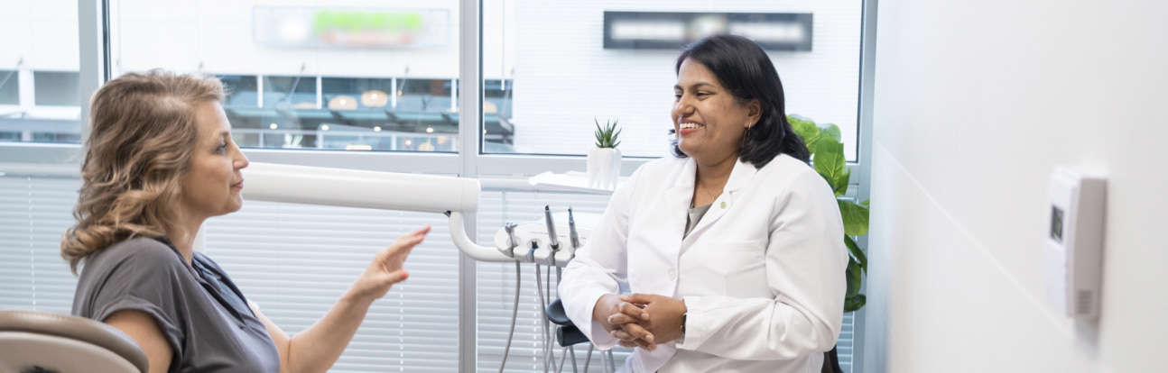 Dr. Madhavan is smiling while speaking with her happy, smiling patient
